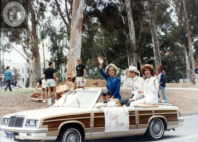 Miss and Mister Gay Pride wave from parade car