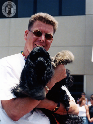 Doug Case holding dog at Pride parade, 1998