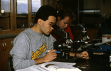 Students use microscope in science laboratory