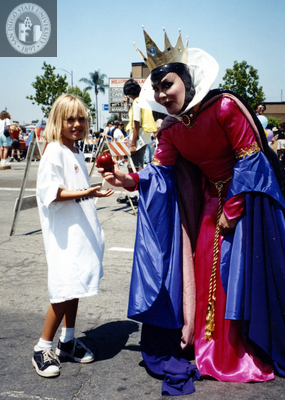 Evil Queen from Snow White gives child an apple in Pride parade, 1996