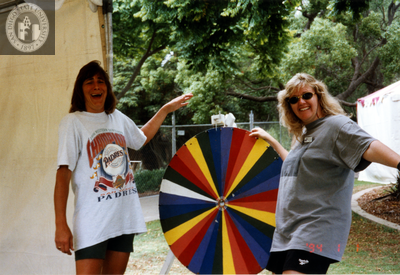 Center volunteers with wheel of fortune at Pride festival, 1998