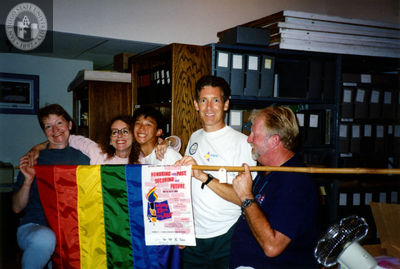 People hold a flag at the Lesbian and Gay Historical Society, 1994