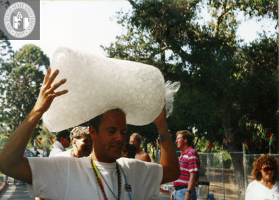 Person carrying large ice bag on their head outside Pride grounds