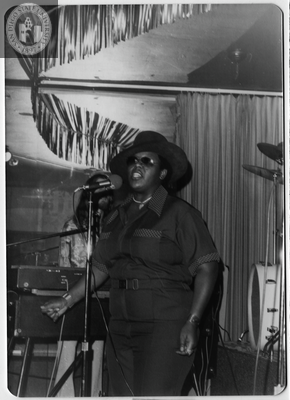 Al Bess singing into microphone with keyboardist in the background