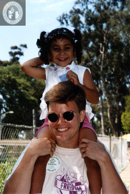 Person carrying child on shoulders at For the Children, 1996