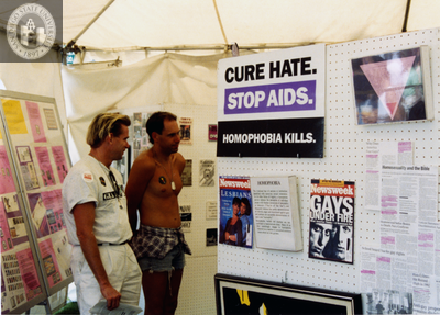 Two attendees looking at LGHSSD booth at Pride festival, 1993