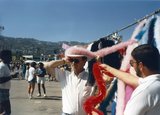 Man trying on hat decoration at Pride festival, 1985