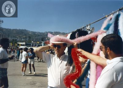 Man trying on hat decoration at Pride festival, 1985