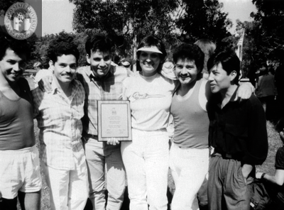 Group of people hold a plaque at Pride festival, 1986