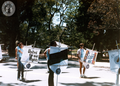Lambda Archives participants holding signs in Pride parade