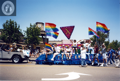 Participants on The Center float waving to the crowd at Pride parade, 1998
