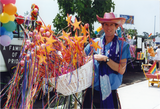 Individual holding basket of toy wands at Pride parade