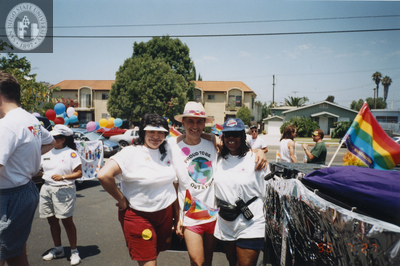 Cheli Mohamed standing with two individuals next to float at Pride parade, 1996