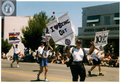 "I love being out 83" sign and Judy Reif at Pride parade, 1999