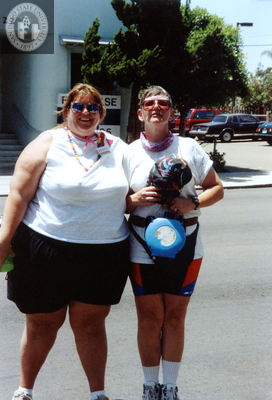 Patty hugs another person in parking lot at Pride parade, 1992