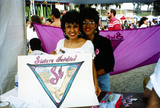 Roberta and Maria holding "Sisters Involved" sign at Pride festival, 1992