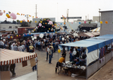 Sign up or vendor booths with balloons strung above at Pride festival, 1982