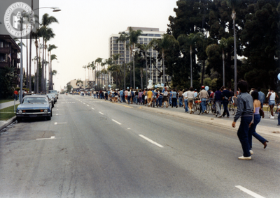 Crowd on sidewalk walking one way, 1982
