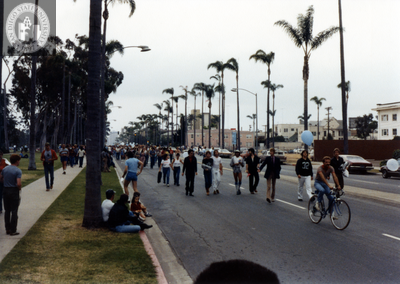 Parade marchers behind person on bicycle in Pride parade, 1982