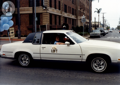 "The Loft" sign on white car at Pride parade, 1982