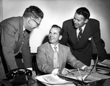 Lionel Van Deerlin stands with two other men in suits