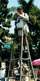 A man on a ladder takes photos at the San Diego Pride Festival, 1997